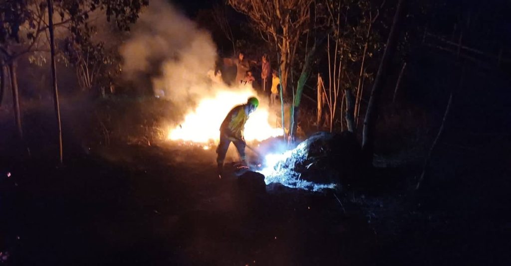 Unidad bomberil combate las llamas de un incendio forestal.