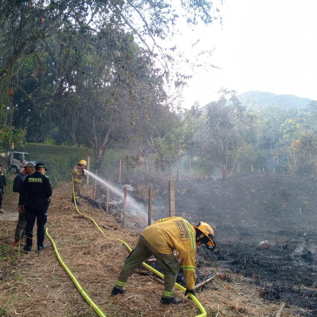 Bombero extingue focos residuales mientras otras unidades apoyan la operación.