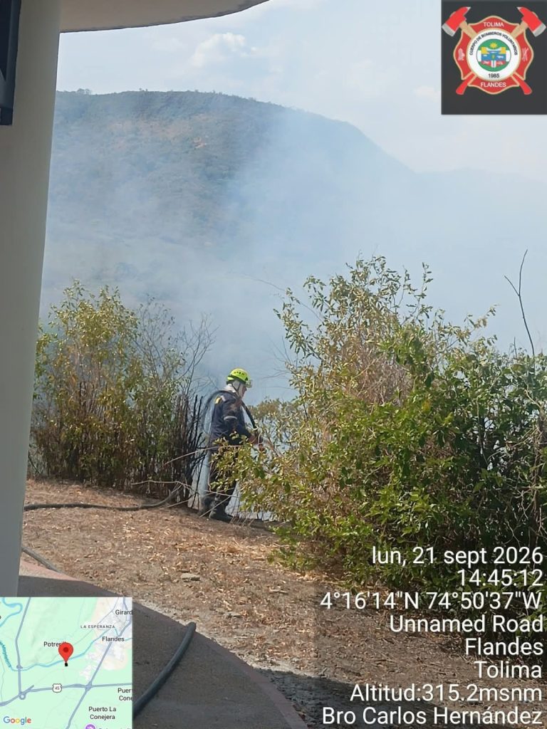 Unidad del Cuerpo de Bomberos Voluntarios de Flandes desarrolla labores de control y extinción entre la vegetación, mientras una densa concentración de humo cubre el área afectada por el incendio forestal en el sector Topacio.