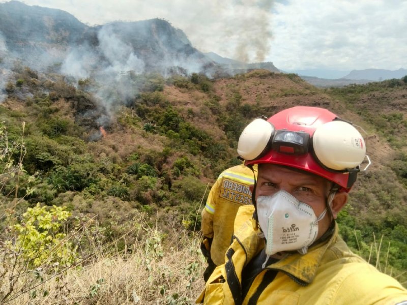 Unidad bomberil equipada con casco, protección respiratoria y traje de intervención durante las labores de control y extinción del incendio forestal en la vereda La Palmita.