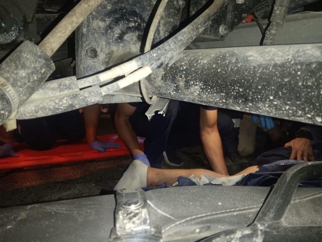 Rescatistas atienden a una de las personas atrapadas debajo del camión