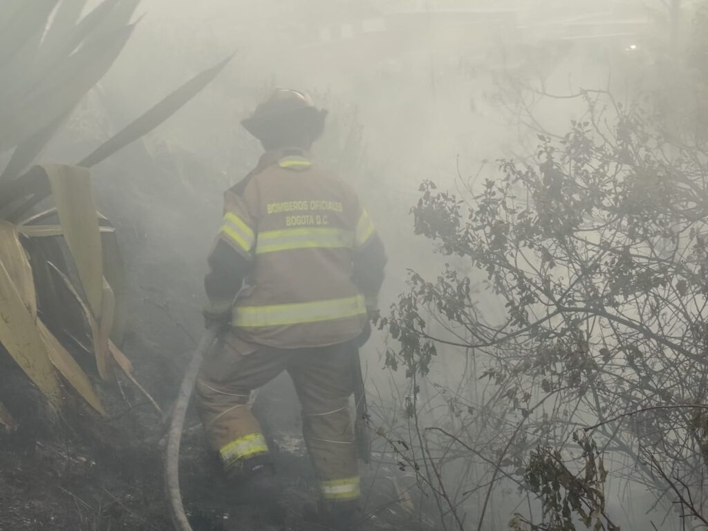 Unidad bomberil durante las labores de extinción en medio del humo generado por el incendio.